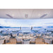 Outdoor dining area on a boat with tables and chairs under a clear sky.
