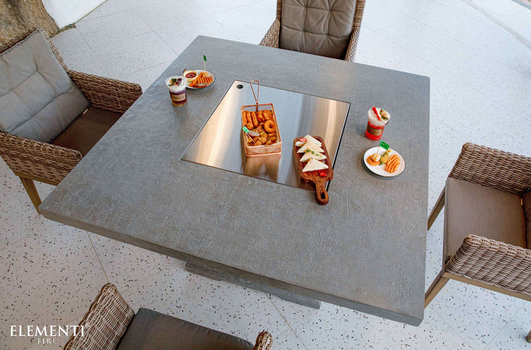 Outdoor Elementi Birmingham Fire Table with Cover table with chairs and food items on a bright day