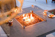 Outdoor Elementi fire pit table with flames and drinks on a patio