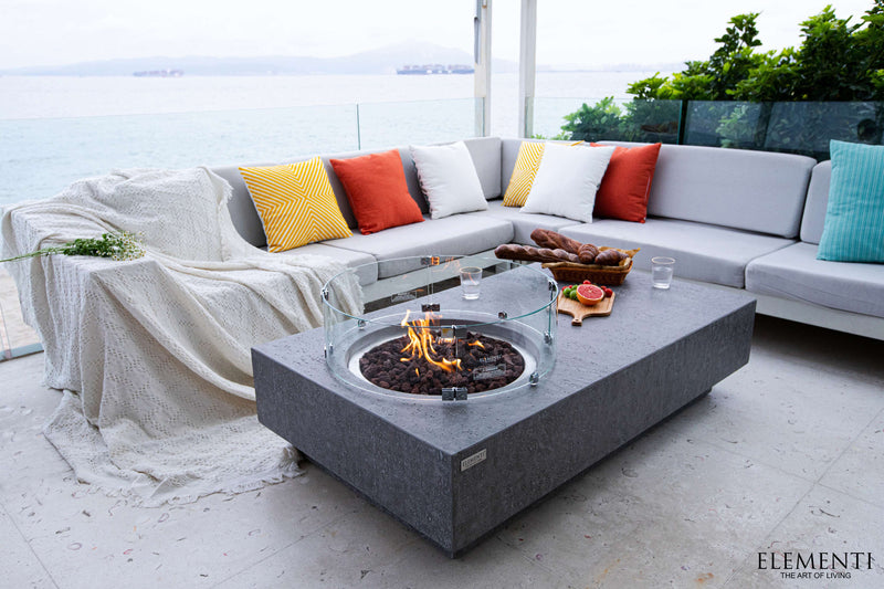 Outdoor patio setup with a sectional sofa and fire pit table on a deck.