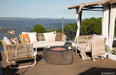 Outdoor patio with wicker furniture, Columbia fire pit by Elementi, and scenic view of water and trees.
