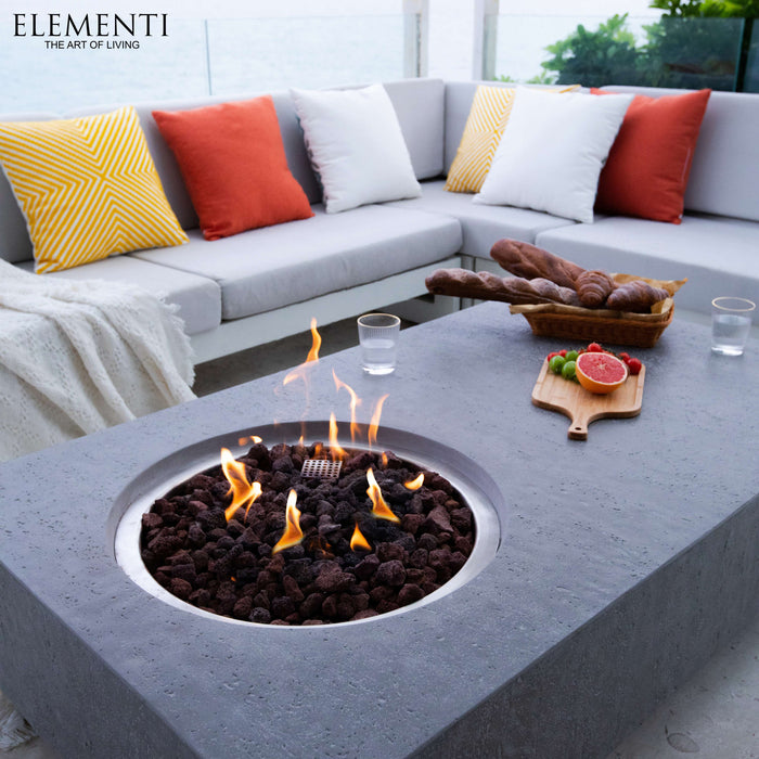 Outdoor patio setting with Elementi fire pit table, seating area, and Elementi branding.