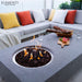 Outdoor patio setting with Elementi fire pit table, seating area, and Elementi branding.