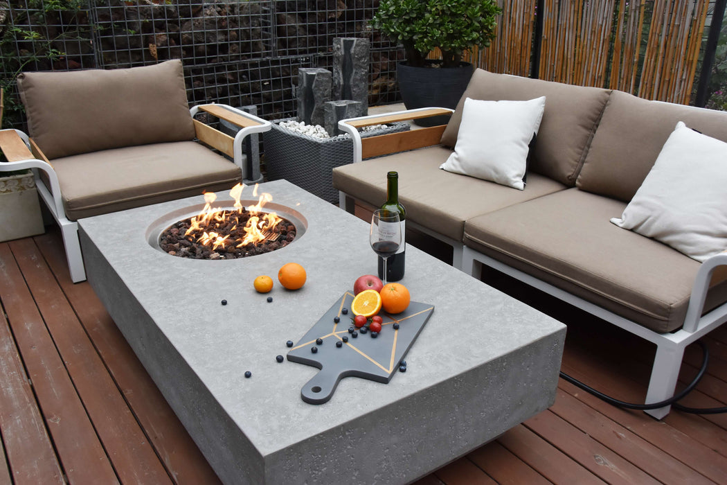 Outdoor patio setup with Elementi Metropolis fire pit table, seating area, and outdoor decor.