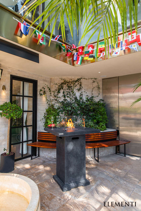 Modern outdoor patio with Elementi Montreal fire pit table, flags, and Elementi branding
