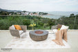 Outdoor patio with chairs, a fire pit, and scenic view of a town and sea.