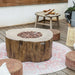 Outdoor patio with fire pit table, lanterns, and cushions on a wooden deck.