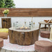 Outdoor patio setting with a fire pit table, cushions, and decorative items.