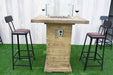 Wooden outdoor Elementi Rova bar table with stools on a grassy area