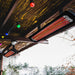 Bromic Tungsten patio heaters under a wooden pergola with decorative lights.