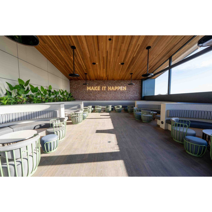 Bromic Eclipse Patio Heaters Modern indoor space with wooden ceiling, plants, and motivational quote on wall.