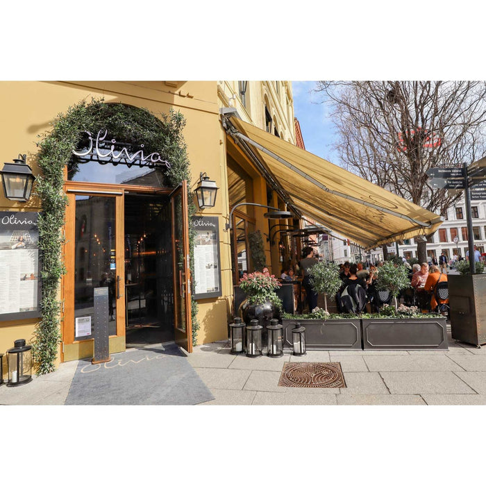 Restaurant exterior with 'Olivia' sign, outdoor seating area, and passersby.