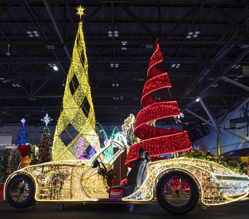 Decorative Christmas display with illuminated trees and car in a indoor setting