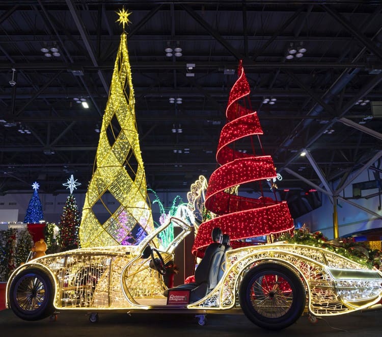 Decorative Christmas display with illuminated trees and car in a indoor setting