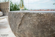 Close-up of a stone fire pit with 'Elementi' branding in an outdoor setting.