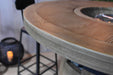 Round wooden Elementi Lafite table with a metal ring in the center, blurred background