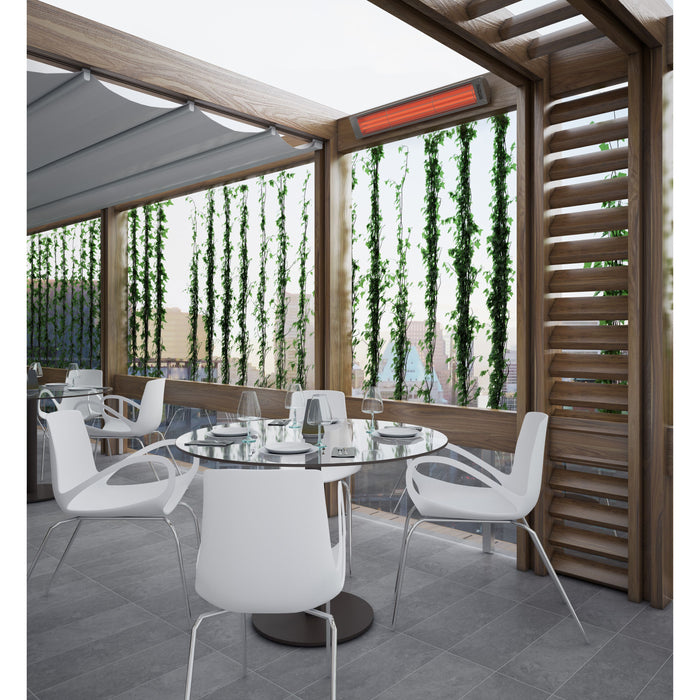 Modern outdoor dining area with white chairs and a round table near a wooden structure with glass panels and a Bromic Cobalt Heater mounted above to the wood.
