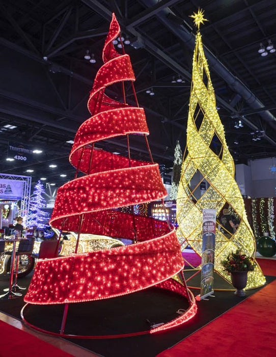 Red and gold spiral Christmas trees at a indoor event.