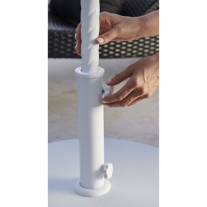 Person adjusting a white Helux umbrella stand on a light surface