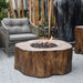 Outdoor setting with a fire pit, chair, and large vase in an urban garden.
