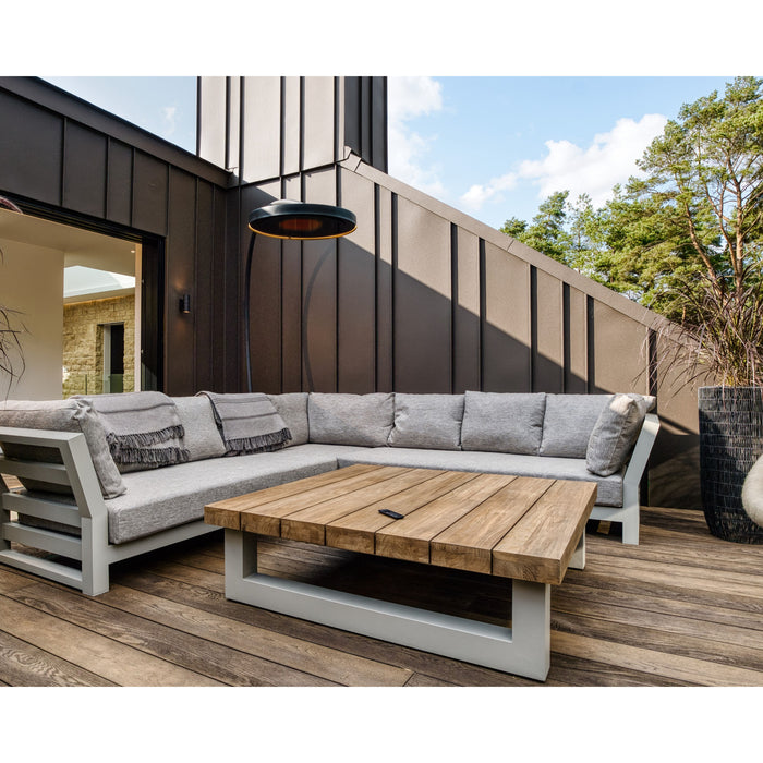 Outdoor patio set with sectional sofa and wooden coffee table on a deck overseen by a Bromic Eclipse Portable patio heater, showcasing a residential application