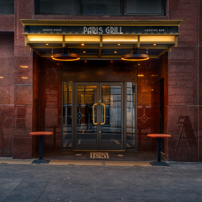 Entrance to a restaurant named 'Paris Grill' with a warm glow from the Bromic Eclipse Heaters
