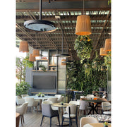 Modern restaurant interior with tables, chairs, and hanging Bromic Eclipse Heaters that are also being used as lights.