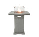 Concrete Elementi Montreal fire table that has an ignited flame with glass cover on a white background