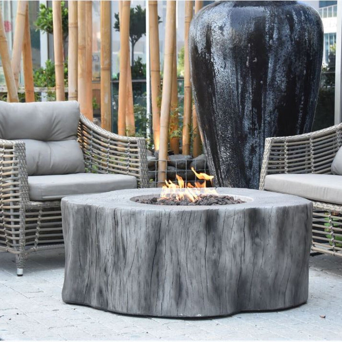 Outdoor patio setting with wicker chairs and a Elementi Manchester fire pit table.