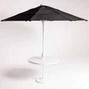 Black patio umbrella on a white stand against a white background