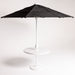 Black patio umbrella on a white stand against a white background