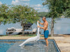 Man lifting a white TenJam Laylo Lounger out of a pool to empty the water of out it