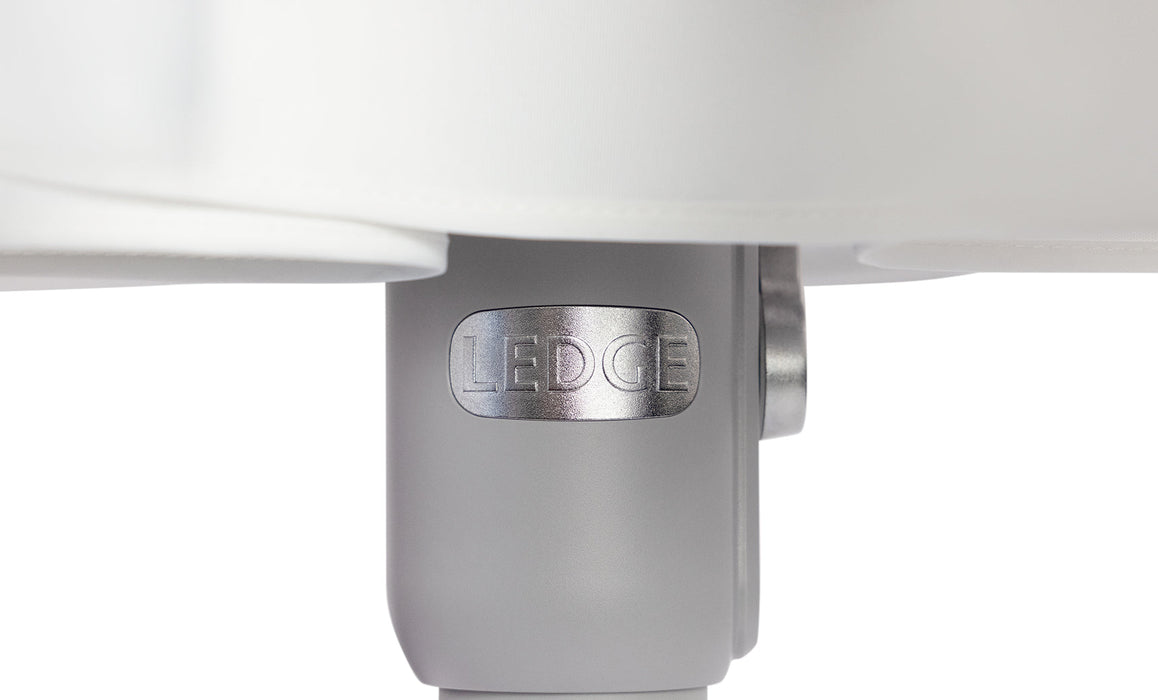 Close-up of a white umbrella with 'Ledge' branding on a light gray background