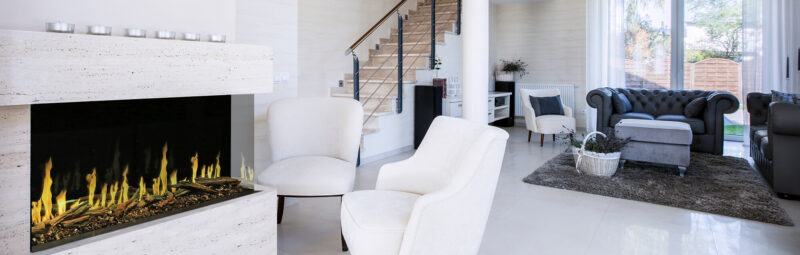 Modern living room with a fireplace, white sofa, and gray armchair.