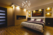 Modern bedroom with a bed, wall art, and chandelier.