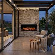 Outdoor patio with stone fireplace, chairs, and a small table.