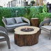 Outdoor patio setting with wicker chairs and a fire pit table.