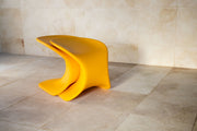Two TenJam Drift chairs stacked on top of one another on a tiled floor with a beige wall background