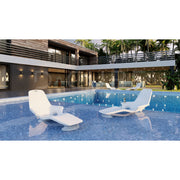 Modern poolside area with two Shayz lounge chairs pictured in a large pool with a house in the background