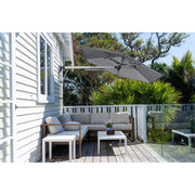 Shadowspec Retreat Wall Mounted Umbrella at a tilted angle providing shade over a patio sectional.