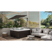 Rendered image of the Shadowspec Retreat wall mounted umbrella tilted and providing shade over a hot tub