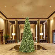 Decorative Christmas tree in a luxurious indoor setting with high ceilings and large columns.
