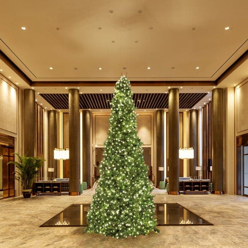 Decorative Christmas tree in a luxurious indoor setting with high ceilings and large columns.