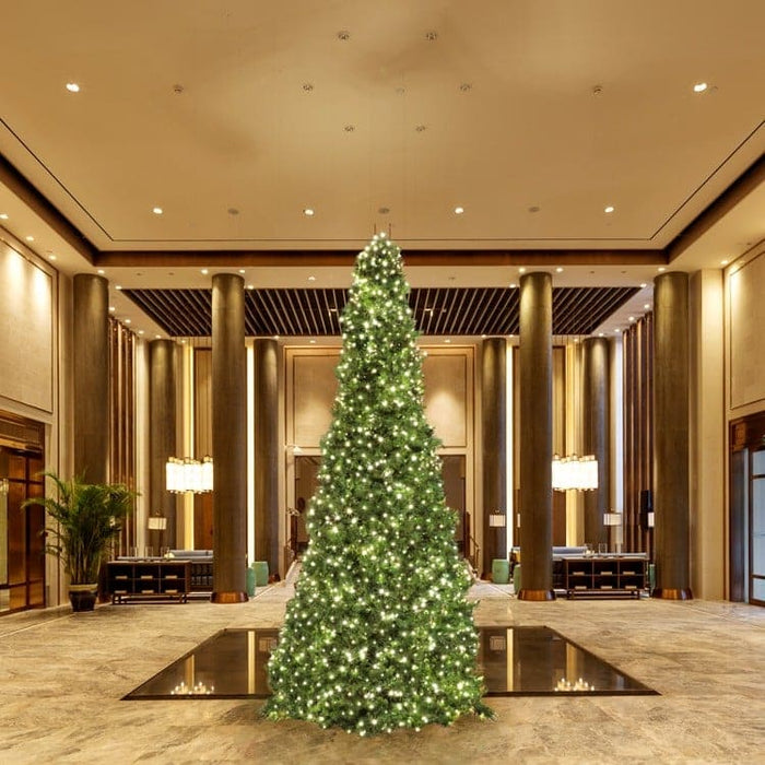 Decorative Christmas tree in a luxurious indoor setting with high ceilings and large columns.