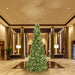 Decorative Christmas tree in a luxurious indoor setting with high ceilings and large columns.