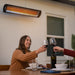 Two people toasting with wine glasses at a table with a Bromic heater above.