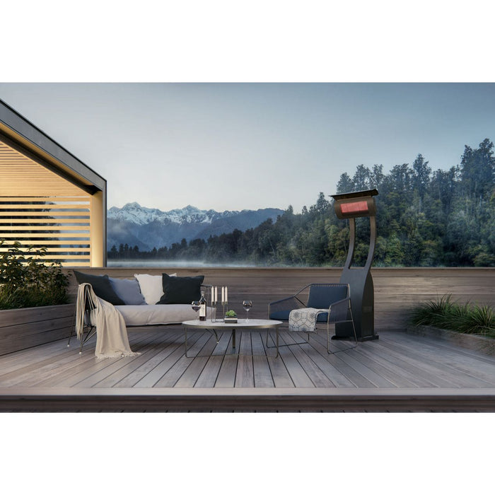 Modern outdoor living space with a sofa, coffee table, and black freestanding directional heater on a wooden deck with a scenic view.