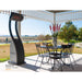 Outdoor patio with black metal table and chairs, infrared gas heater, and scenic background.