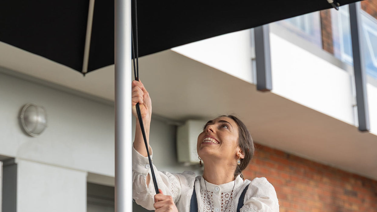 Woman holding an umbrella in front of a building entrance