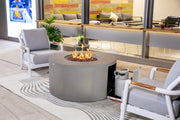 Modern outdoor patio with fire pit, chairs, and a colorful wall in the background